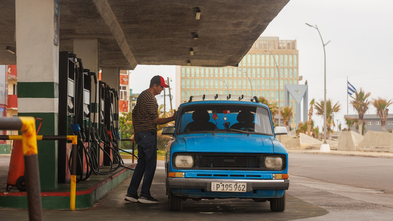 A Cuban fills his car up at the gas station in Havana.