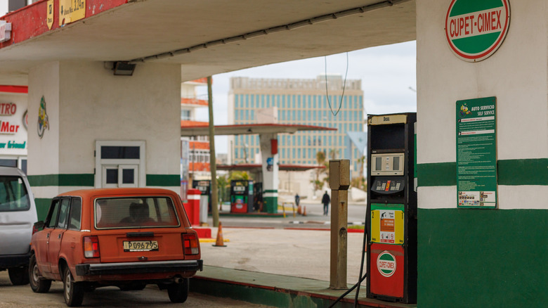 Cars sit at a Cuban gas station that has no fuel.