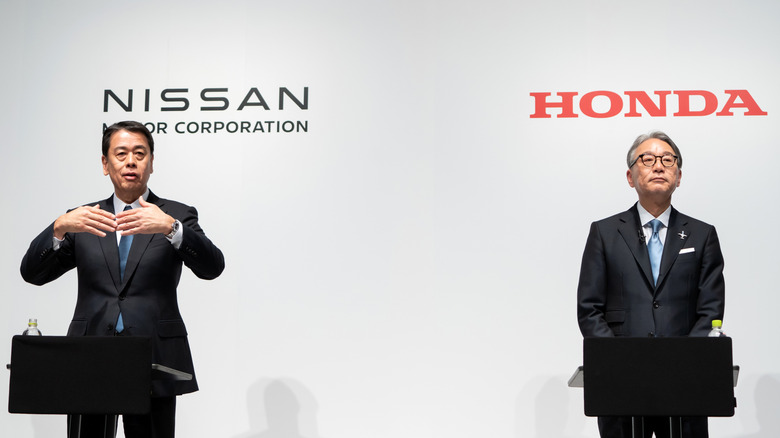 TOKYO, JAPAN - MARCH 15: Nissan Motor CEO Makoto Uchida (L) speaks as Honda Motor CEO Toshihiro Mibe (R) listens during a joint press conference on March 15, 2024 in Tokyo, Japan. The automakers announced their partnership on electric vehicles today to compete with rival EV manufacturers such as China's BYD or US-based Tesla. (Photo by Tomohiro Ohsumi/Getty Images)