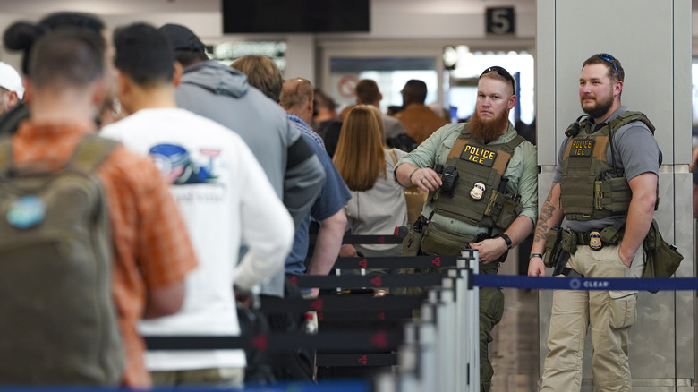 ICE agents stand next to the security line at Atlanta Hartsfield-Jackson International Airport on March 23, 2026 in Atlanta, Georgia.