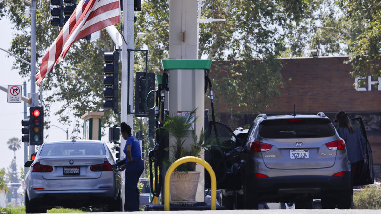 An American flag flies beyond customers gathered at a gas station on May 11, 2026 in Arcadia, California.