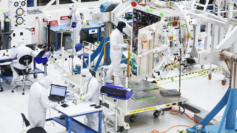 Engineers work on the Europa Clipper spacecraft in a sterilized chamber at NASA's Jet Propulsion Laboratory in 2023