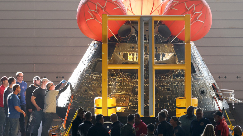 Engineers inspect the Orion capsule from the Artemis I mission to the Moon and back in December 2022