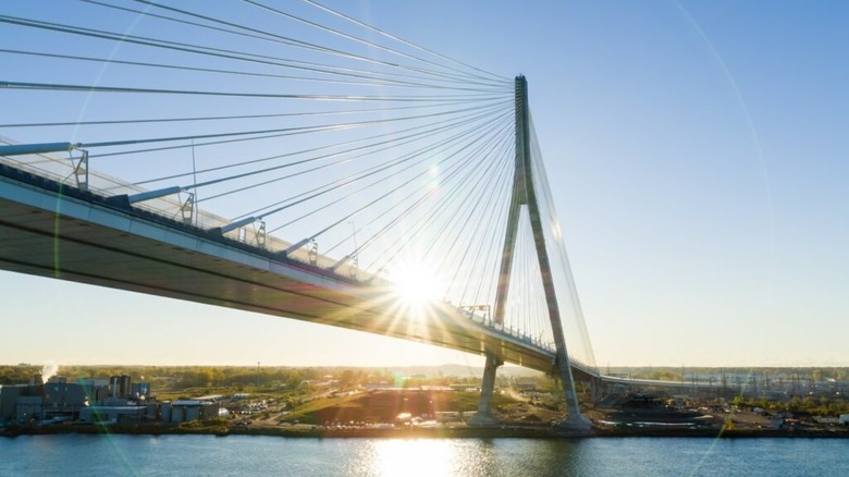 The sun rising over the Gordie Howe International Bridge stretching across the Detroit River.