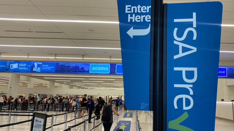 An "Enter Here" and a "TSA PreCheck" sign at the security entrance to an airport