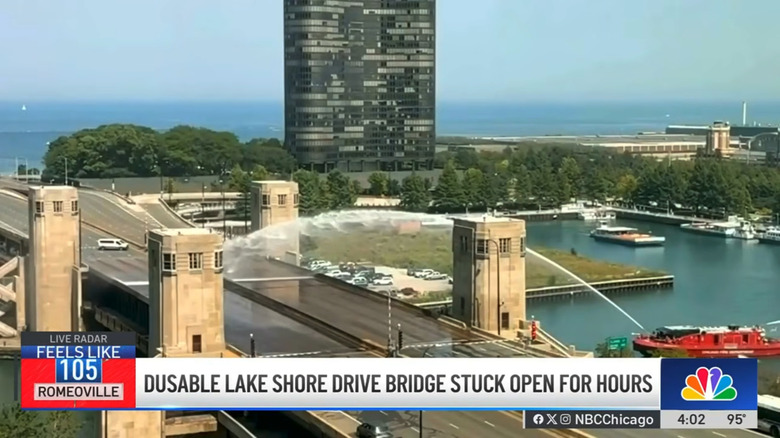 A Chicago firefighting boat sprays water onto the DuSable Lake Shore Drive Bridge to cool it off after a malfunction, screenshot from NBC 5 Chicago newscast on YouTube.
