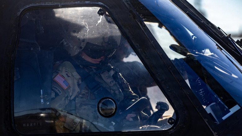 A 101st Combat Aviation Brigade pilot adjusts her equipment in the cockpit of a UH-60 Black Hawk helicopter before conducting egress testing with the Advanced Inflight Relief Universal System (AIRUS) at Fort Campbell, Kentucky, Oct. 6, 2026.
