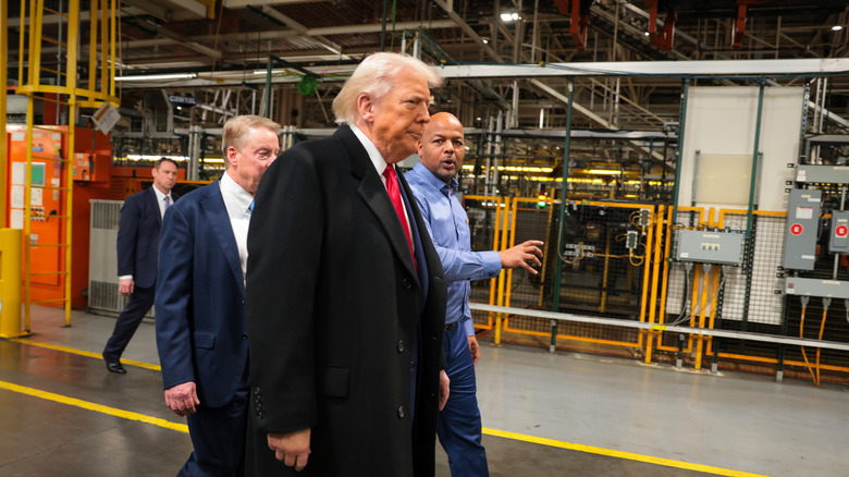 Trump looking angry while walking the floor of a Ford factory