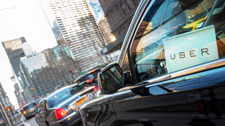 A black SUV sports an "Uber" sign in its window.