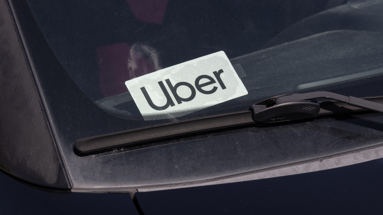 An Uber sign in the windshield of a ridesharing car