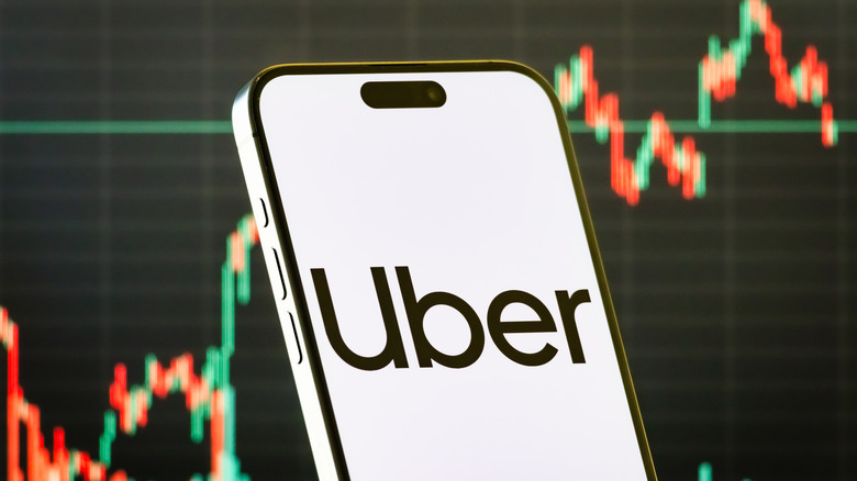 An iPhone screen showing the uber logo posed in front of a stock market chart that is climbing.