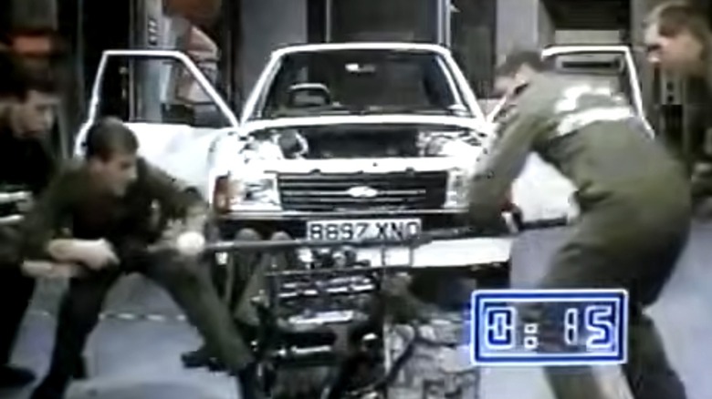 A marine team lifting engine into Ford Escort MK3