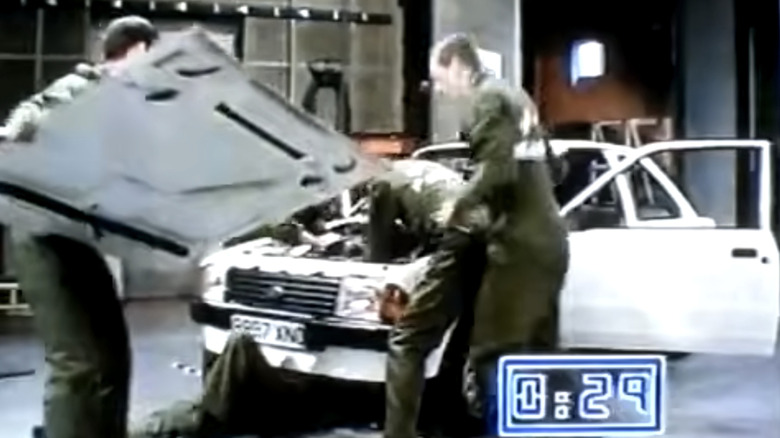 A marine team placing the hood back on the Ford Escort MK3