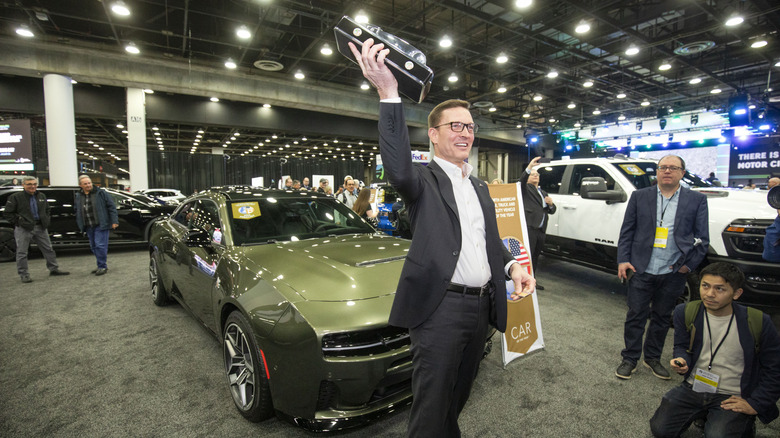 Dodge brand CEO Matt McAlear hoists the trophy after the Dodge Charger won the Car of the Year Award at the 2026 North American Car, Truck, and Utility Vehicle of the Year Awards at the 2026 Detroit Auto Show on January 14, 2026 in Detroit, Michigan.