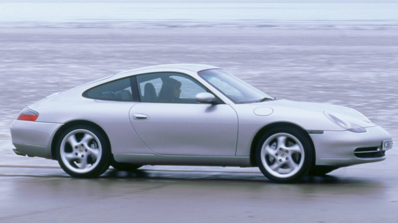 Silver Porsche 911 coupe driving on a wet surface