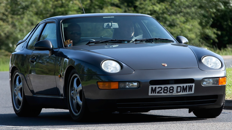 Dark gray Porsche 968 coupe driving on the road