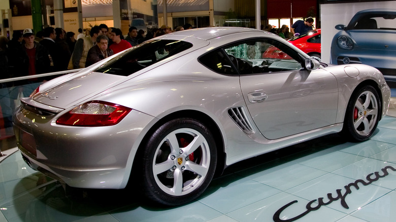 Silver Porsche Cayman S on display at an indoor car show