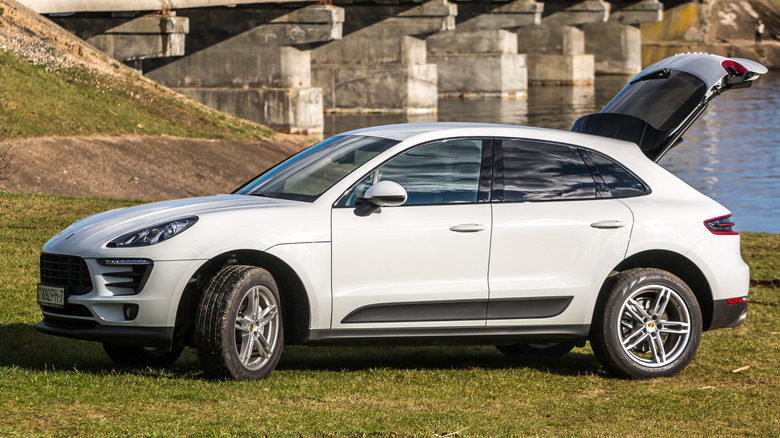 A white Porsche Macan with the rear hatch open parked outside