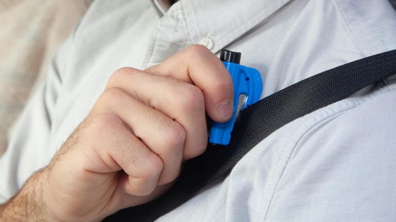 Man holds Resqme 2 in 1 escape tool in blue.