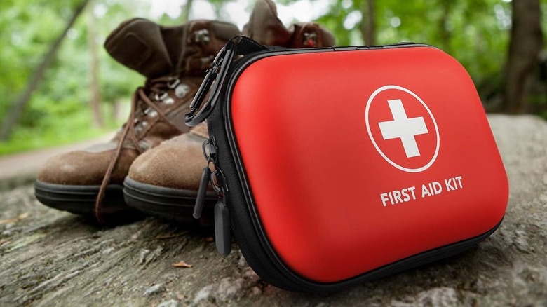 Closeup of the THRIAID first aid kit leaning up against a pair of boots.