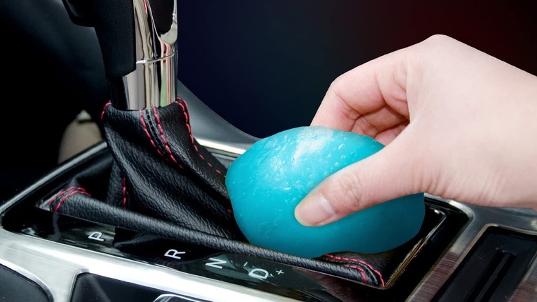 A Ticarve cleaning gel is used on the leather shifter boot of a vehicle.
