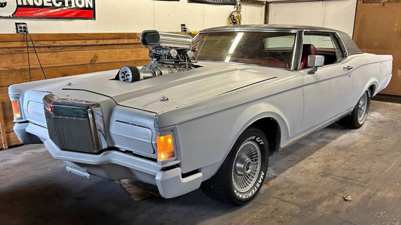 Gray Lincoln Continental with a supercharger through the hood