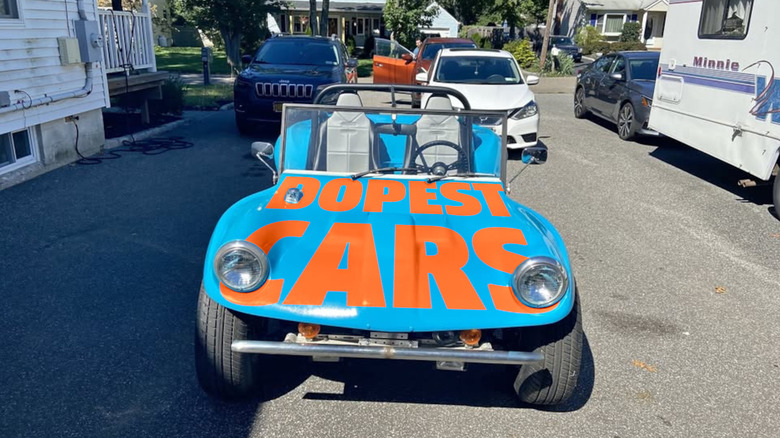 A blue dune buggy with the text DOPEST CARS