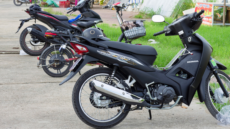Motorbikes and scooters are parked by the roadside at Hoa Phu Industrial Park as workers conclude their shifts in the afternoon.