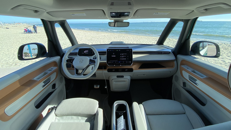 A wide shot showing the panoramic view from out the windshield and front side windows on the ID Buzz parked on the sand in front of the ocean