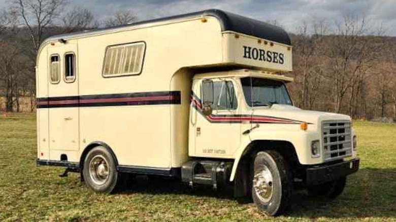 A beige International truck labeled HORSES