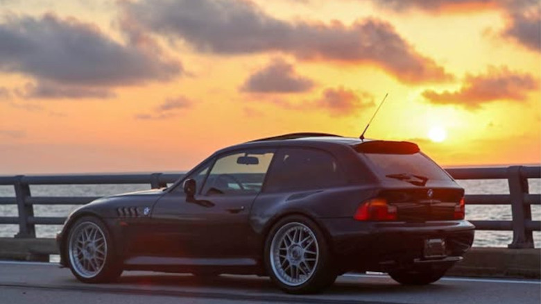 A BMW Z3 clownshoe in front of a sunset