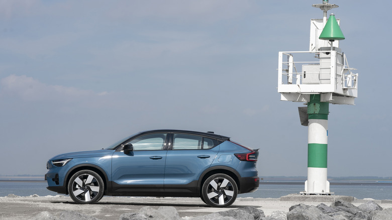 Side view of a blue C40 parked on a rocky jetty next to a green and white tower