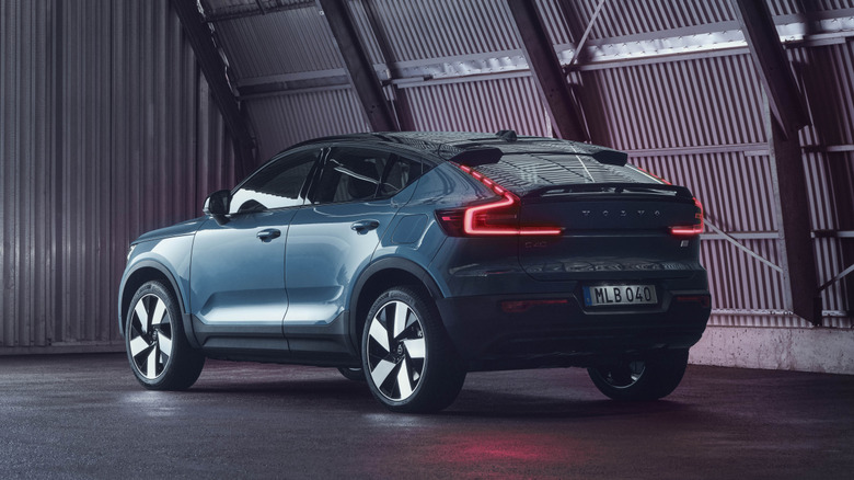 rear three-quarters shot of a blue C40 parked in a hangar with its rear lights on