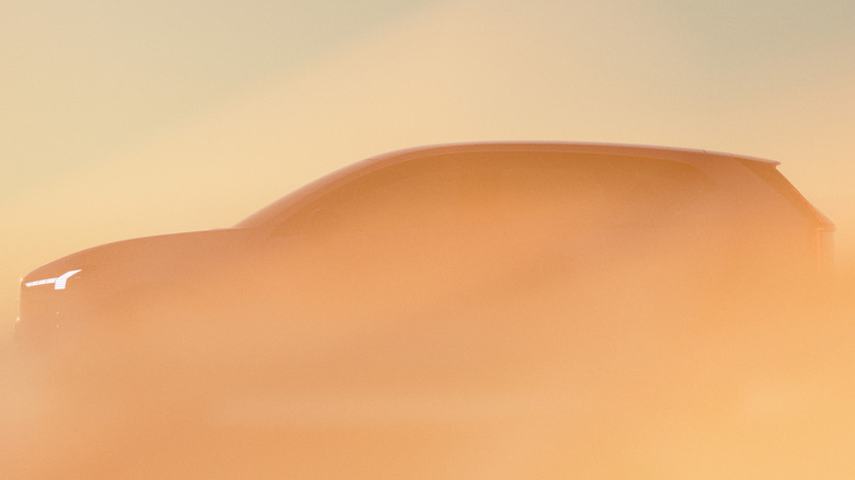 A side view of the profile of the new EX60, with only its DRLs visible through a peach-colored haze