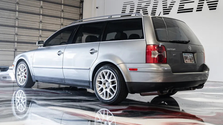 A rear three-quarters shot of the silver Passat W8 wagon parked in a garage with the word driven on the wall