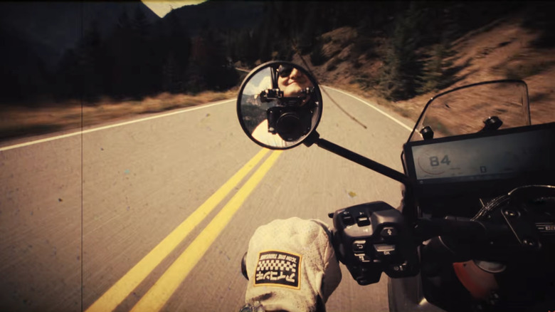 Rider view of a Can-Am Origin on a twisty mountain road with Ryan F9's smiling face in the rear view mirror