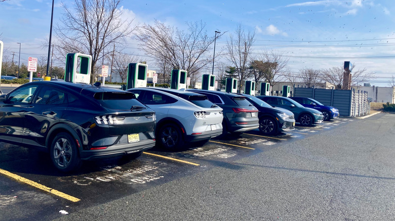 Several electric vehicles parked at chargers in a Walmart parking lot