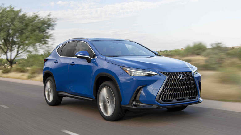 A Grecian Water blue 2026 Lexus NX 350h Luxury crossover driving on a suburban road.