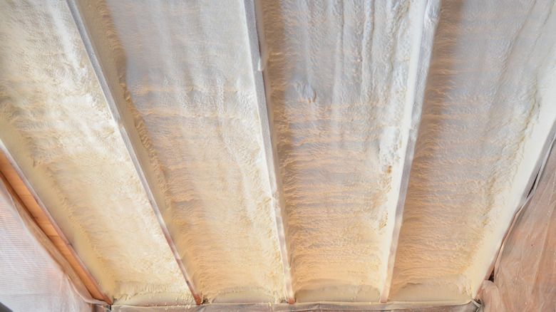Spray in insulation on a metal wall.