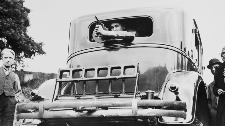 Al Capone's armored Cadillac with a man poking a machine gun out of the rear window