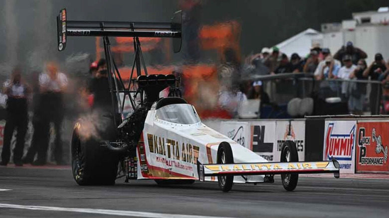 Shawn Langdon's Kalitta Air top fuel dragster spins its tires as it gets ready to go down the dragstrip.