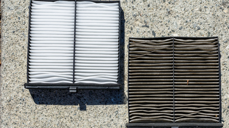 Clean automotive cabin air filter alongside a dirty filter.