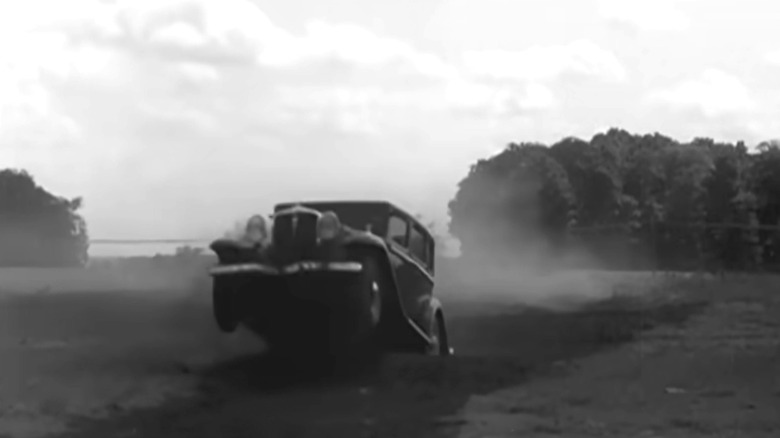 A Studebaker Six sedan's front end is nose in the air after hitting a whoops on a challenging dirt course at its South Bend proving grounds.