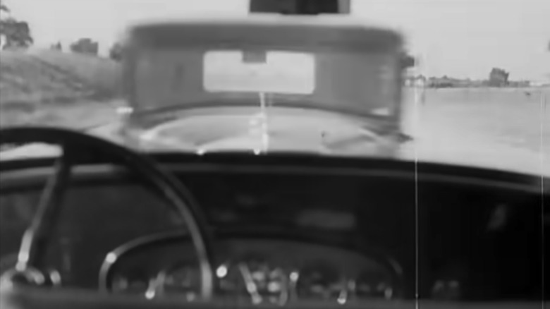 An interior shot from a Studebaker as it drives head-on into another Studebaker at the automaker's proving grounds, in black and white.