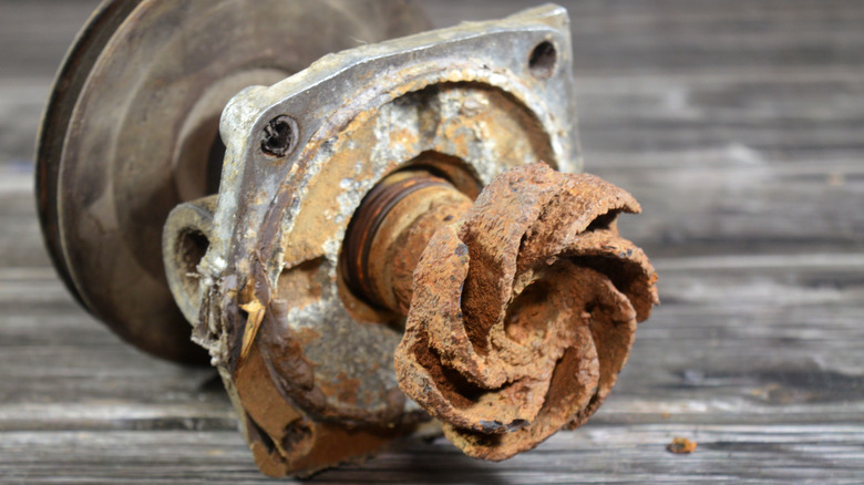 An old, rusted car water pump