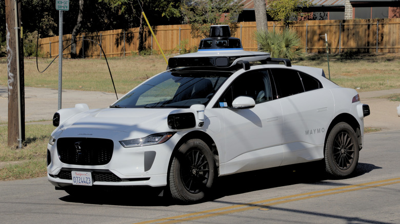 A three-quartets view of a white Waymo autonomous vehicle in Austin, Texas