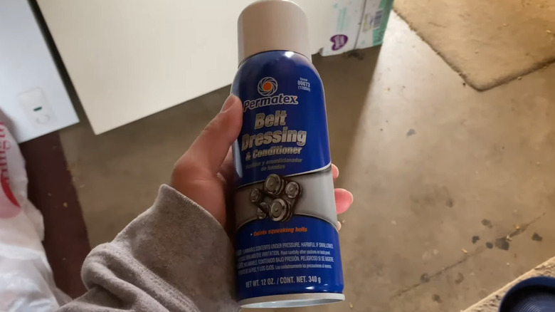 Permatex belt dressing spray held in hand.