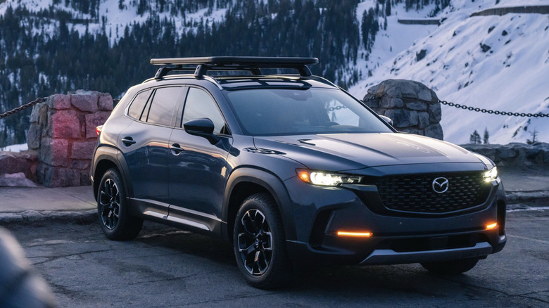 Mazda CX-50 parked in parking lot with snowy mountain sides in the background