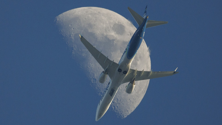 An Alaska Airlines Boeing 737 MAX 9 flies under a half-moon