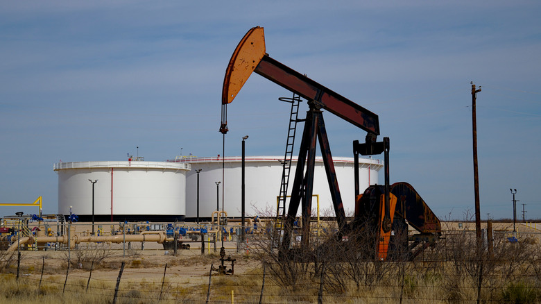 An oil well and storage tanks in a desolate part of the Permian Basin in West Texas.